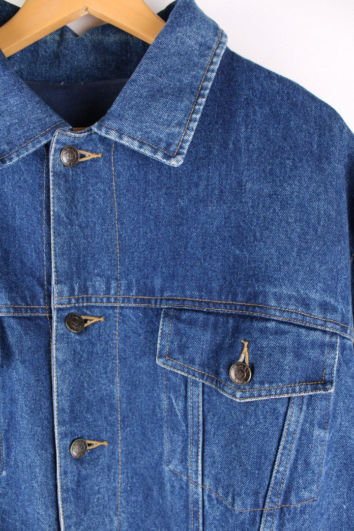 Vintage 1990s Armani Jeans denim jacket in a blue colourway. The jacket is reversible on one side is a traditional denim jacket with two breast pockets, and two jetted pockets. When reversed, the jacket becomes a bomber style, with nylon quilted sleeves, a denim collar and soft cotton panels with pouch pocket detail.  