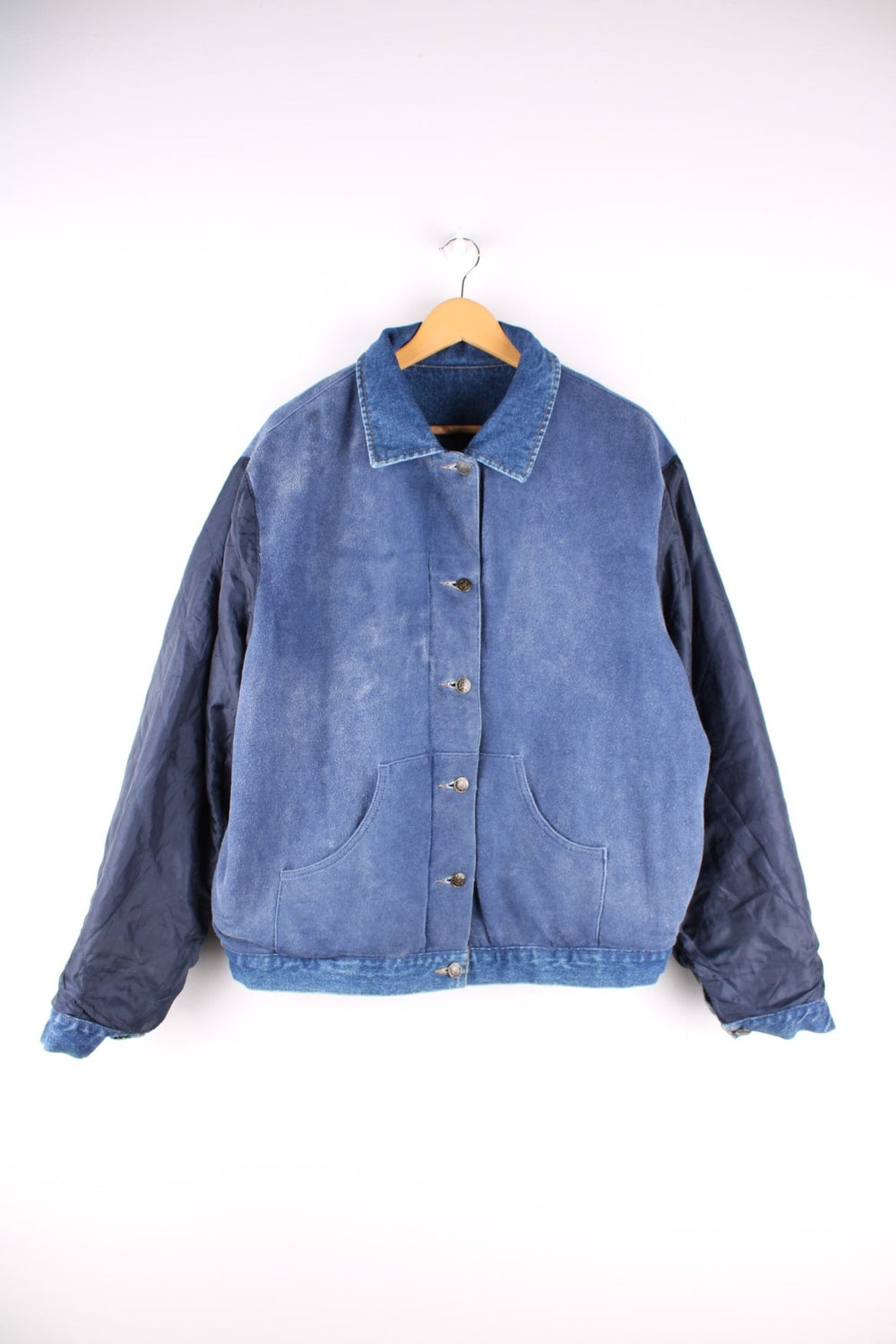 Vintage 1990s Armani Jeans denim jacket in a blue colourway. The jacket is reversible on one side is a traditional denim jacket with two breast pockets, and two jetted pockets. When reversed, the jacket becomes a bomber style, with nylon quilted sleeves, a denim collar and soft cotton panels with pouch pocket detail.  