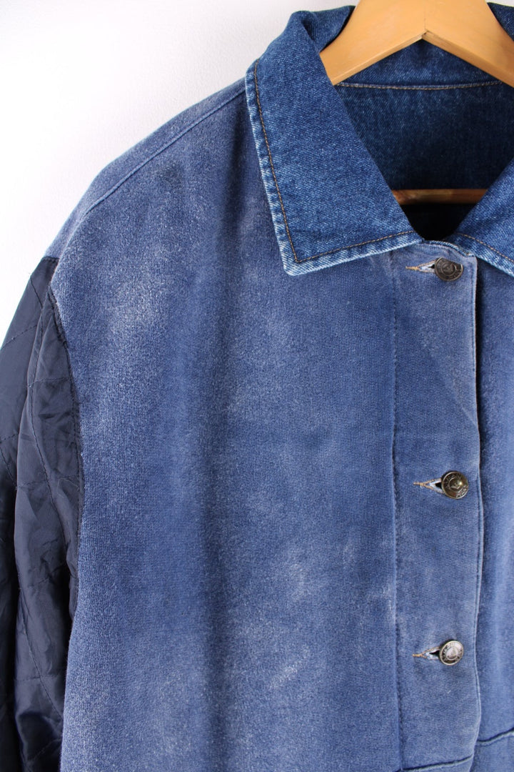 Vintage 1990s Armani Jeans denim jacket in a blue colourway. The jacket is reversible on one side is a traditional denim jacket with two breast pockets, and two jetted pockets. When reversed, the jacket becomes a bomber style, with nylon quilted sleeves, a denim collar and soft cotton panels with pouch pocket detail.  