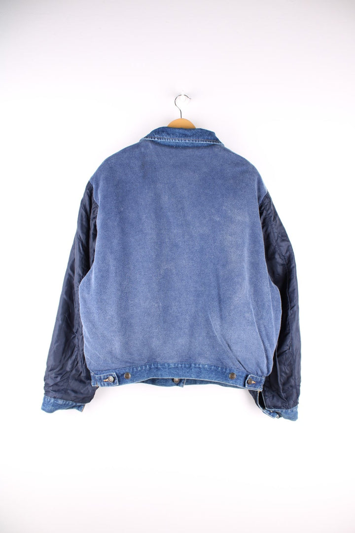 Vintage 1990s Armani Jeans denim jacket in a blue colourway. The jacket is reversible on one side is a traditional denim jacket with two breast pockets, and two jetted pockets. When reversed, the jacket becomes a bomber style, with nylon quilted sleeves, a denim collar and soft cotton panels with pouch pocket detail.  