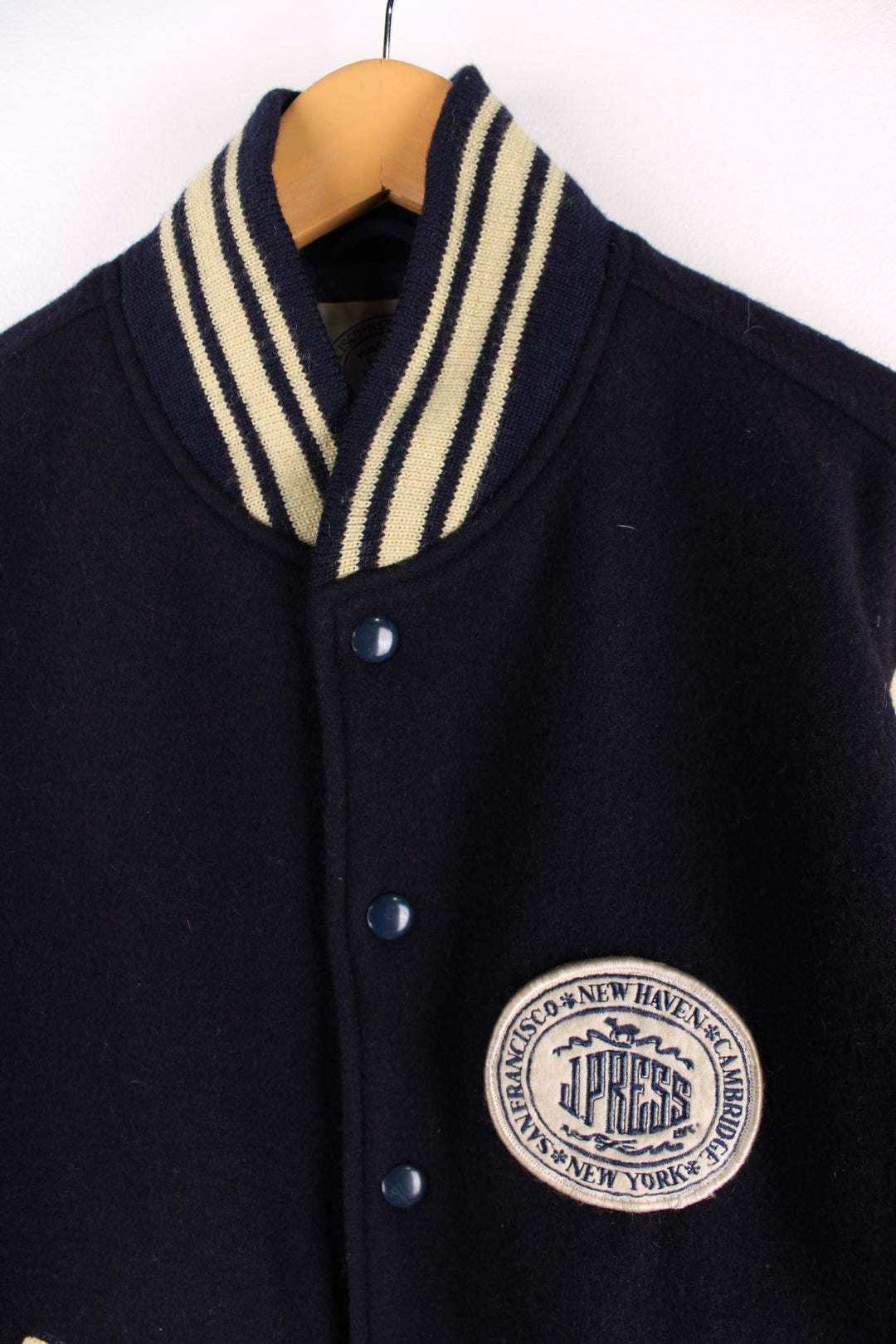 Vintage J Press Varsity Jacket in navy blue with cream sleeves and detail, The jacket has two jetted pockets, a J Press Patch on the front and elasticated cuffs.