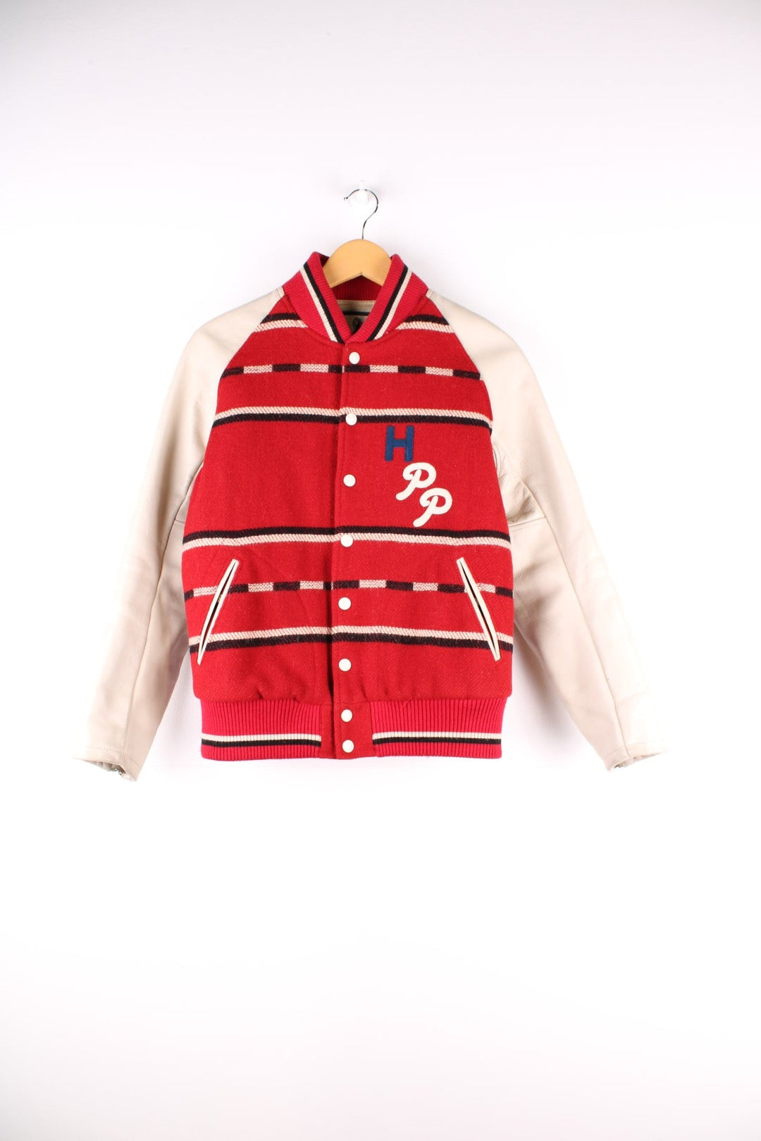 Vintage Hysteric Glamour varsity jacket in a red and cream colourway. The jacket has cream leather sleeves, press studs to close and jetted pockets on the front panels. The jacket is lined with a quilted fabric. and on the back there is a large chain stitched graphic reading 'Hysteric Performance Products'. Hysteric Glamour is a Japanese Streetwear brand, founded in 1984 by artist Nobuhiko Kitamura. 