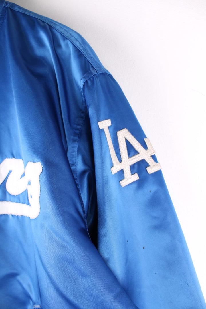 Vintage LA Dodgers baseball jacket in a blue satin colourway. The jacket has the classic elasticated cuffs and collar, press studs to close and was made by Starter, as a part of their Diamond collection and is dated to the 1990S. 