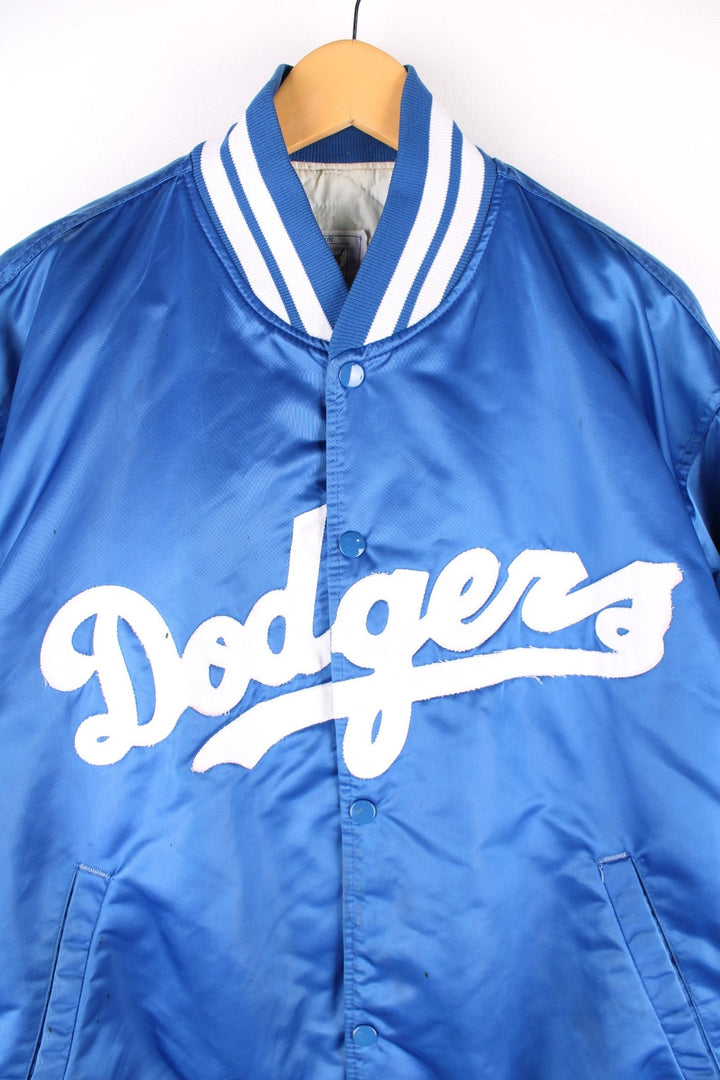 Vintage LA Dodgers baseball jacket in a blue satin colourway. The jacket has the classic elasticated cuffs and collar, press studs to close and was made by Starter, as a part of their Diamond collection and is dated to the 1990S. 