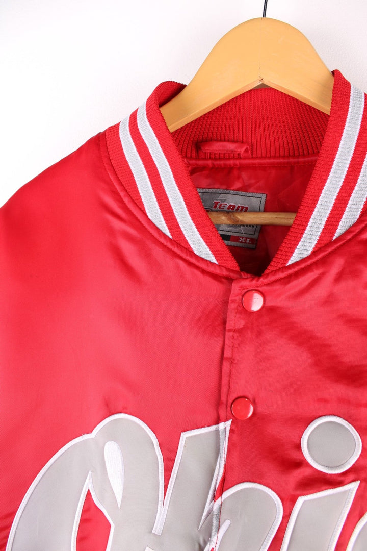 Vintage Ohio State baseball jacket in a red satin colourway. The jacket has the classic elasticated cuffs and collar, two pockets on the front panels and a large Ohio State logo across the chest. There is also a small embroidered patch on the arm.  