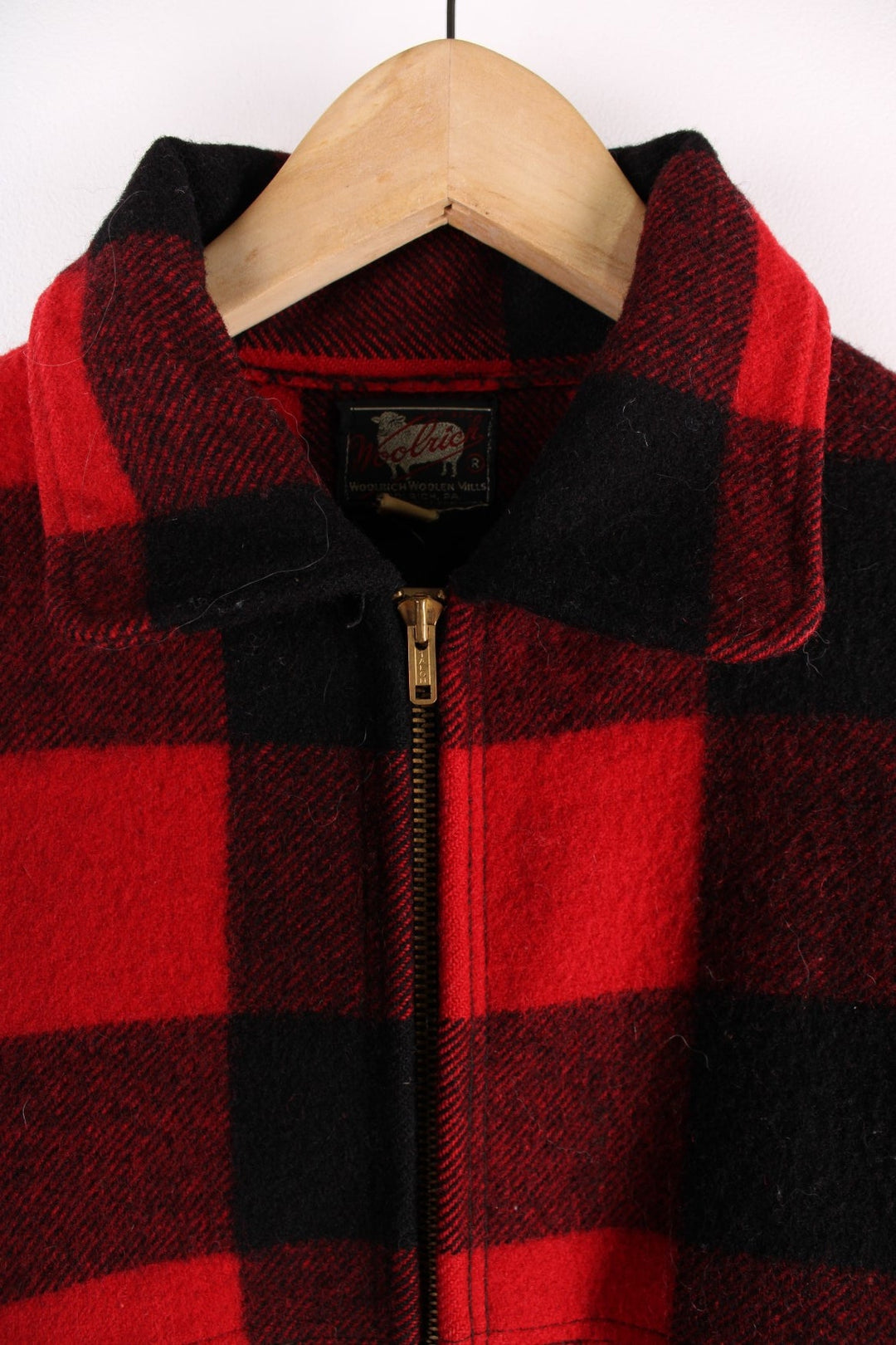 1950s Woolrich CPO Jacket in a red and black checked wool colourway. The jacket has two sets of pockets on the front panels, a talon zipper and the interior of of cuffs is lined with a black cotton fabric.