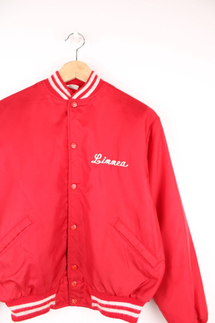 Vintage 1980's 'Birdie' red nylon varsity jacket, features large spell-out motif on the back 'Fox Lane Cross Country' in white. Also has personalised name on the chest and popper button fastening