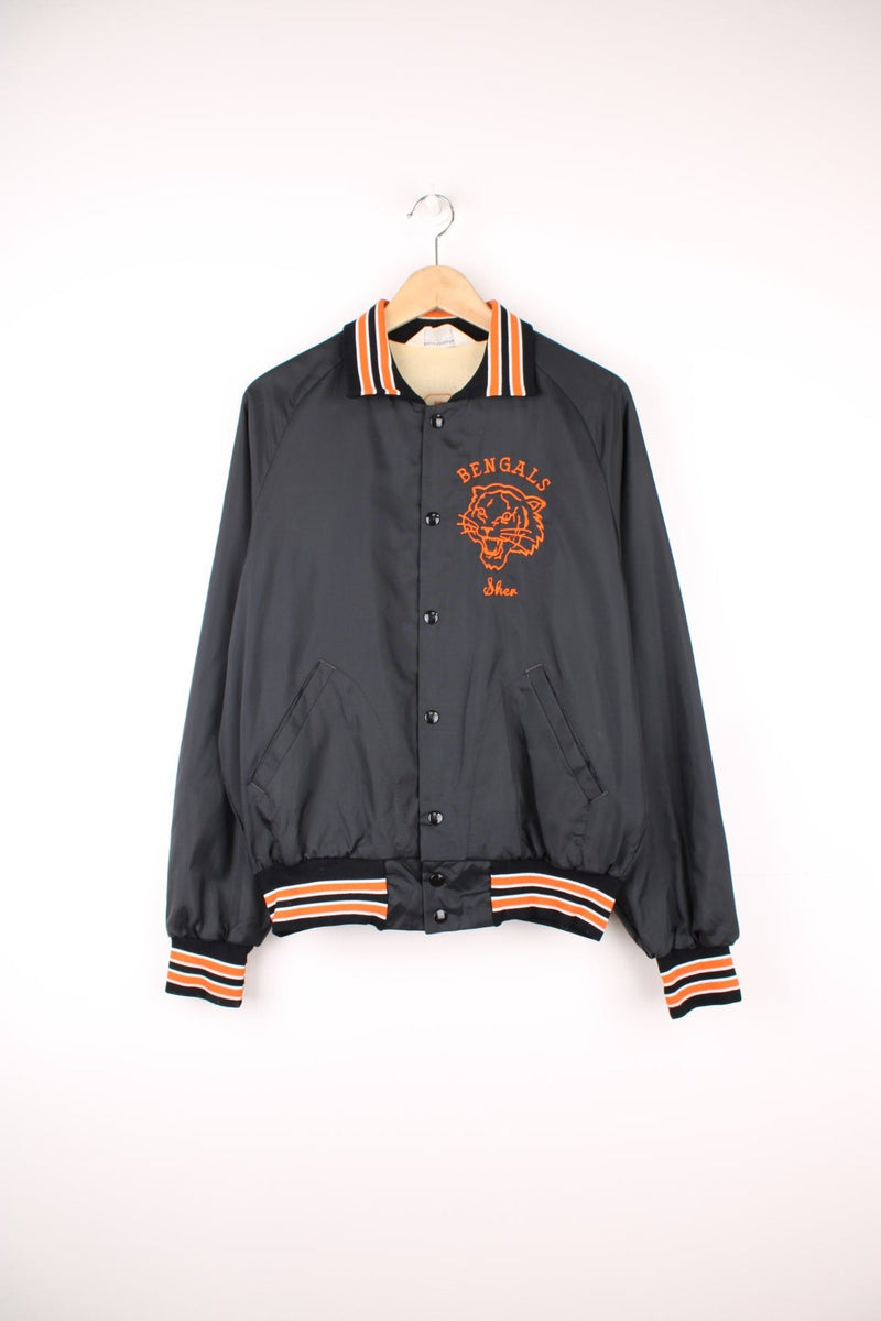 Vintage 1970's / 80's black nylon Bengals themed varsity jacket. Features embroidered spell-out details on the back, tiger badge on the chest and popper button fastening.