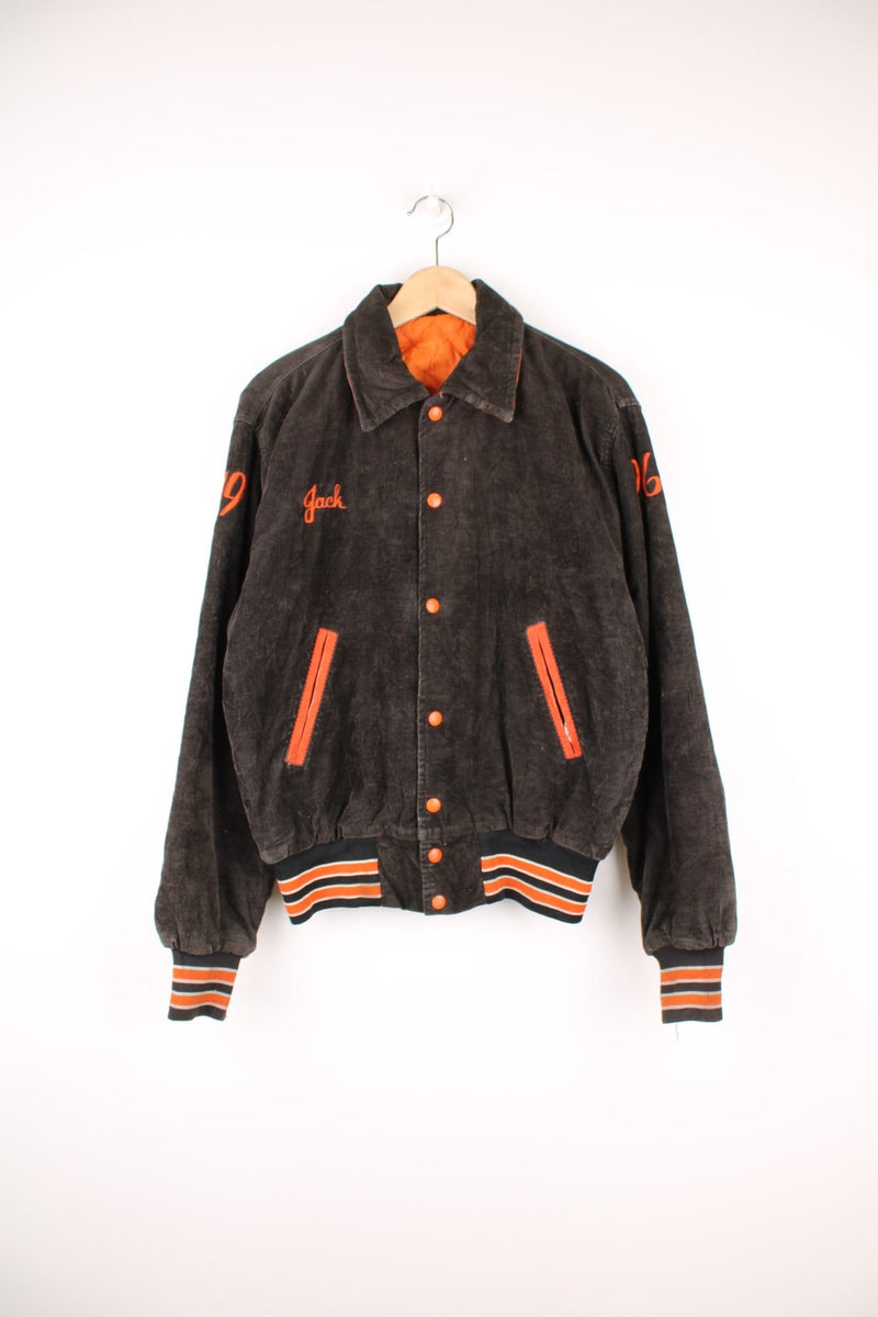 Vintage1996 brown corduroy varsity jacket with 'Gardner' embroidered on the back, features orange details and quilted lining.