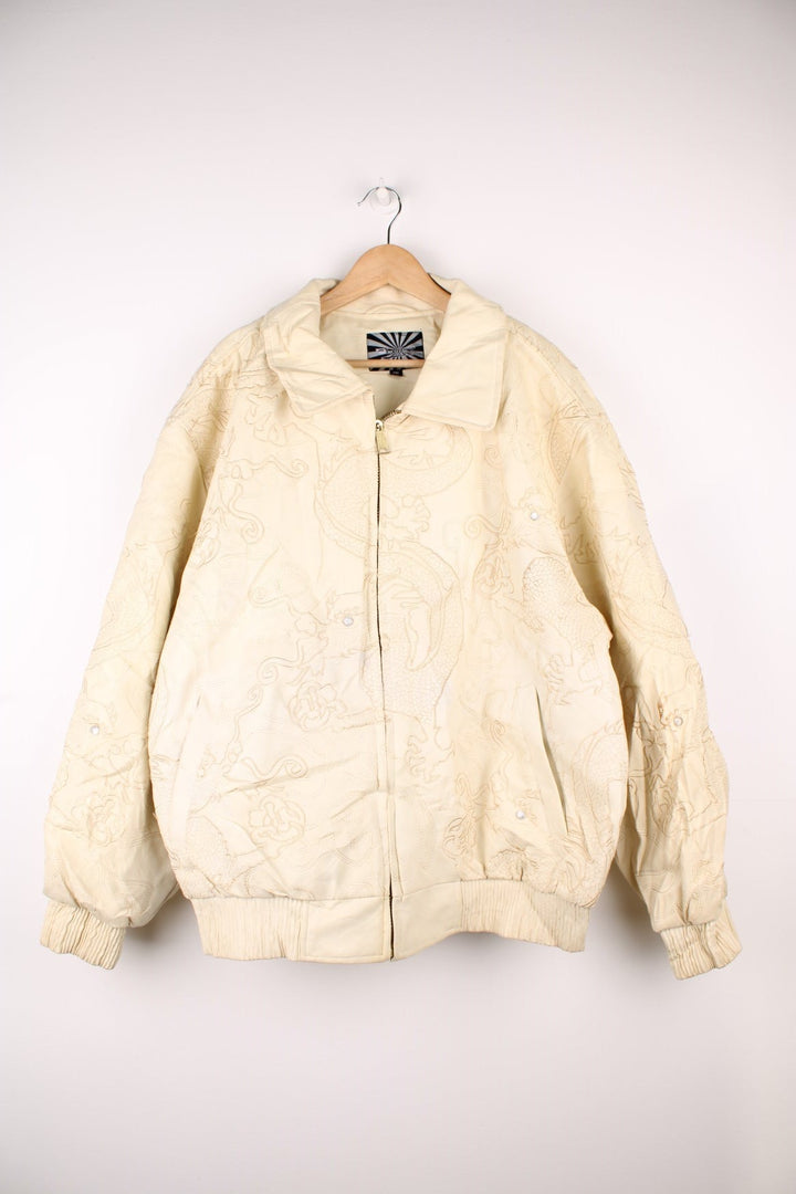 90's Y2K BlueZ Dragon Leather Jacket in a cream colourway, zip up with side pockets, big collar, and has embroidered dragons all over. 