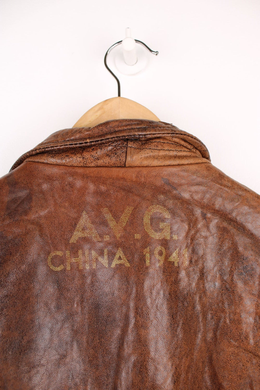 Vintage Avirex Flight Aviator Bomber Jacket in a brown colourway, zip up with side pockets and has badges embroidered on the front alongside the Avirex logo. 