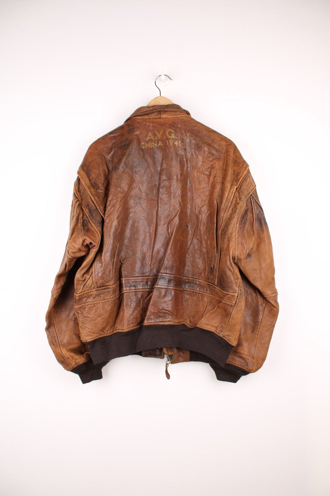 Vintage Avirex Flight Aviator Bomber Jacket in a brown colourway, zip up with side pockets and has badges embroidered on the front alongside the Avirex logo. 