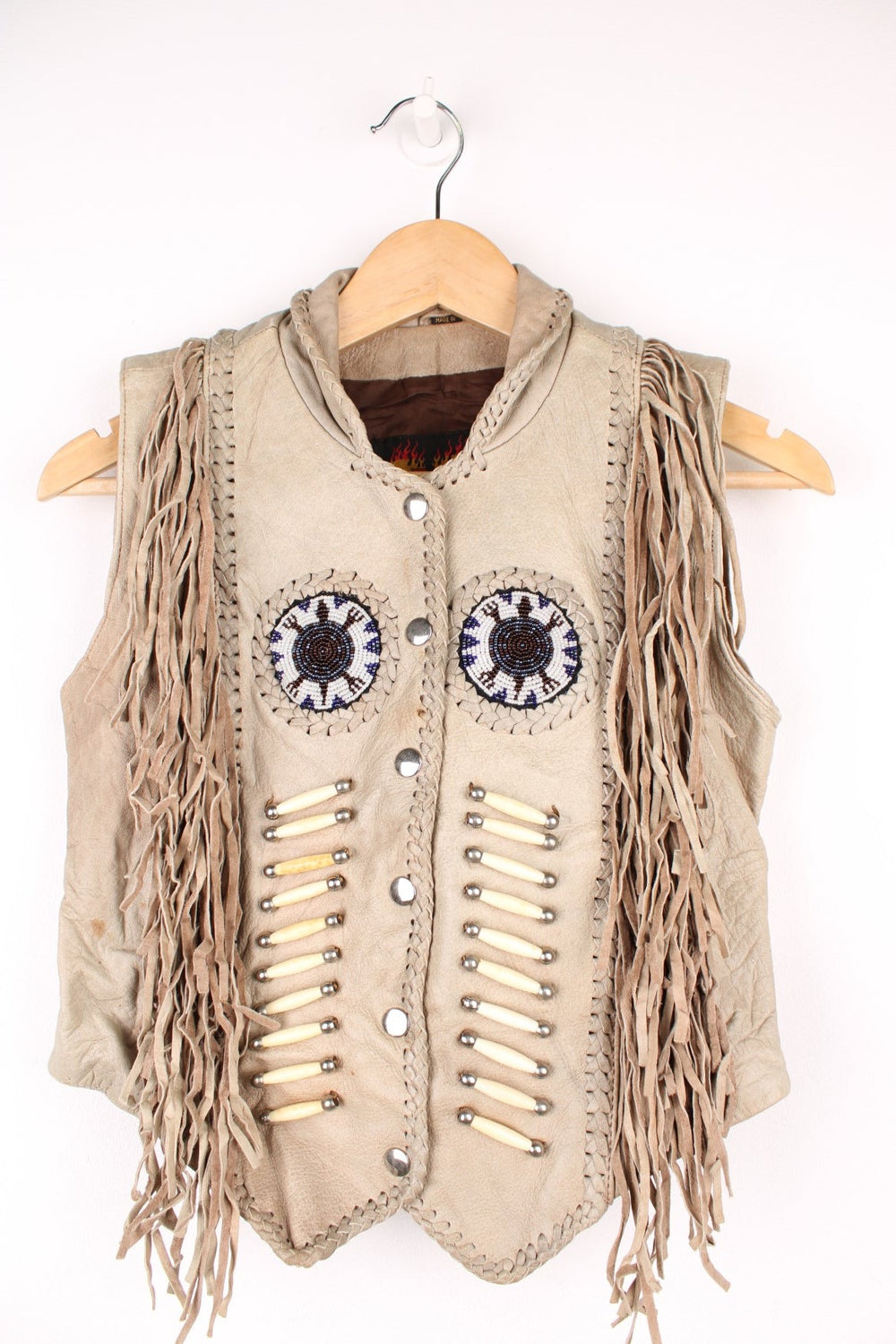 Vintage Native Leather Gilet by 'Hot Leathers' in a tanned colourway, button up, has bones and beades embroiderd on the front alongside the tassels on either side. 