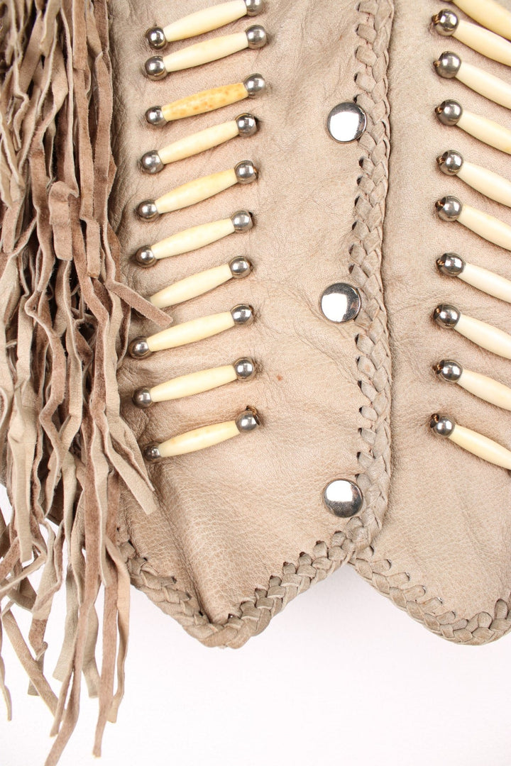 Vintage Native Leather Gilet by 'Hot Leathers' in a tanned colourway, button up, has bones and beades embroiderd on the front alongside the tassels on either side. 