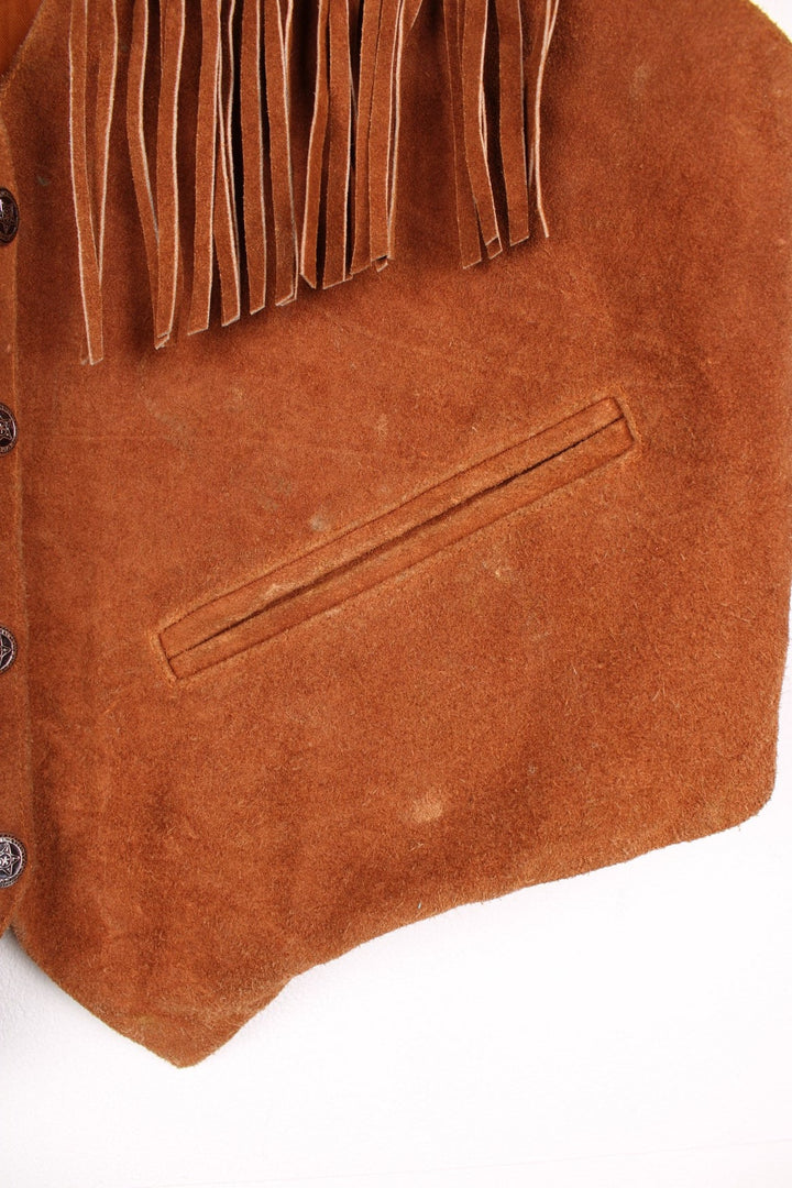 Mona Mode Western Fringe Gilet in a brown colourway, button up with side pockets, and has tassels on the front. 