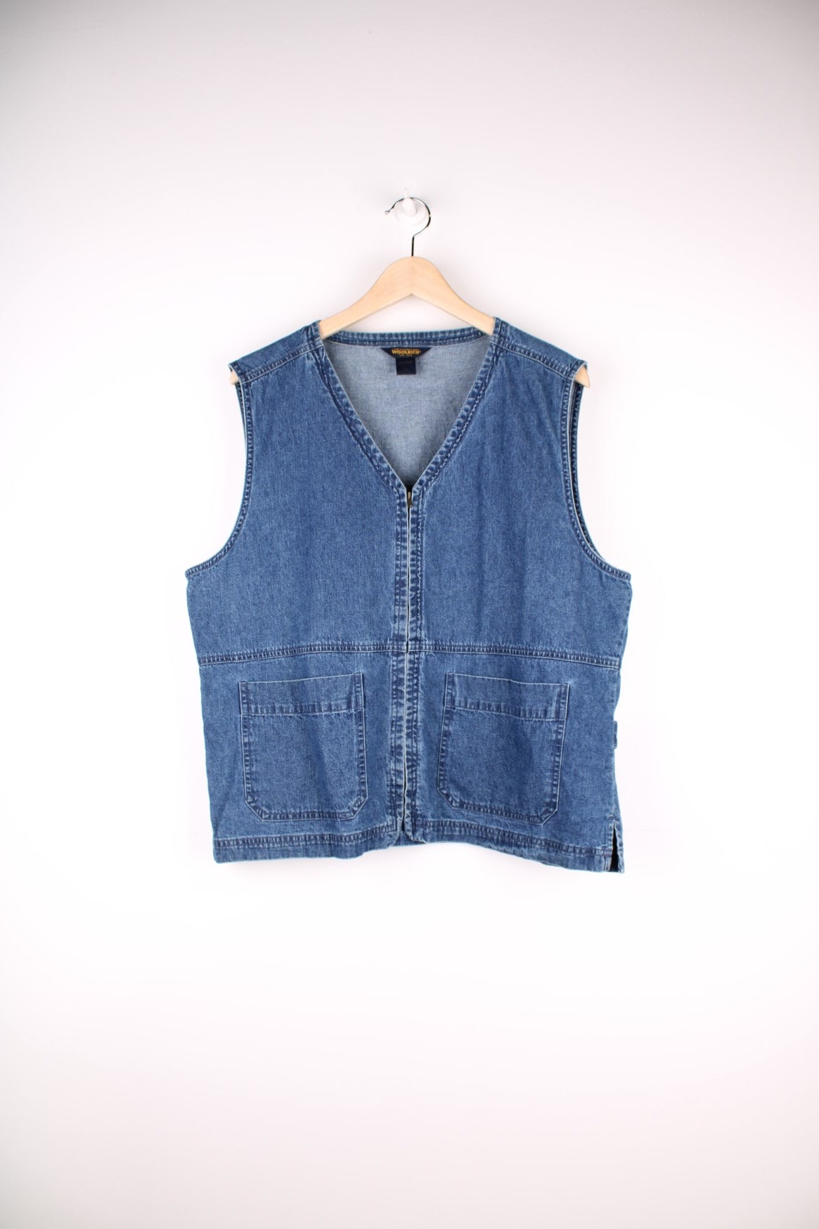 Woolrich Denim Vest in a blue colourway, zips up with a v neck collar and has double pockets on the front. 