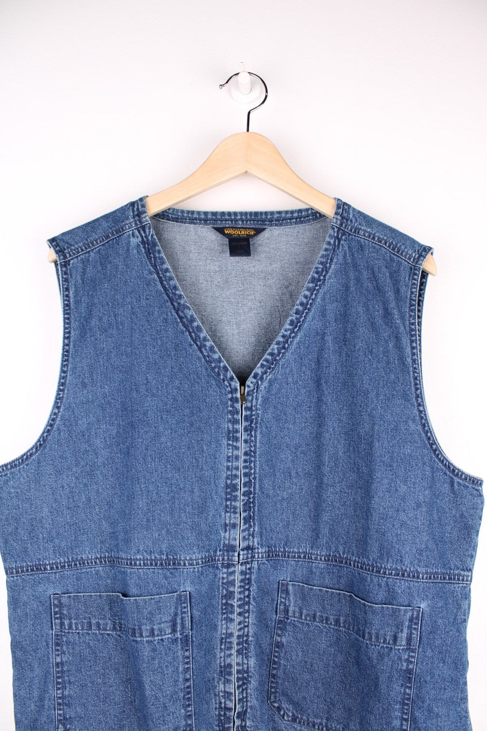 Woolrich Denim Vest in a blue colourway, zips up with a v neck collar and has double pockets on the front. 