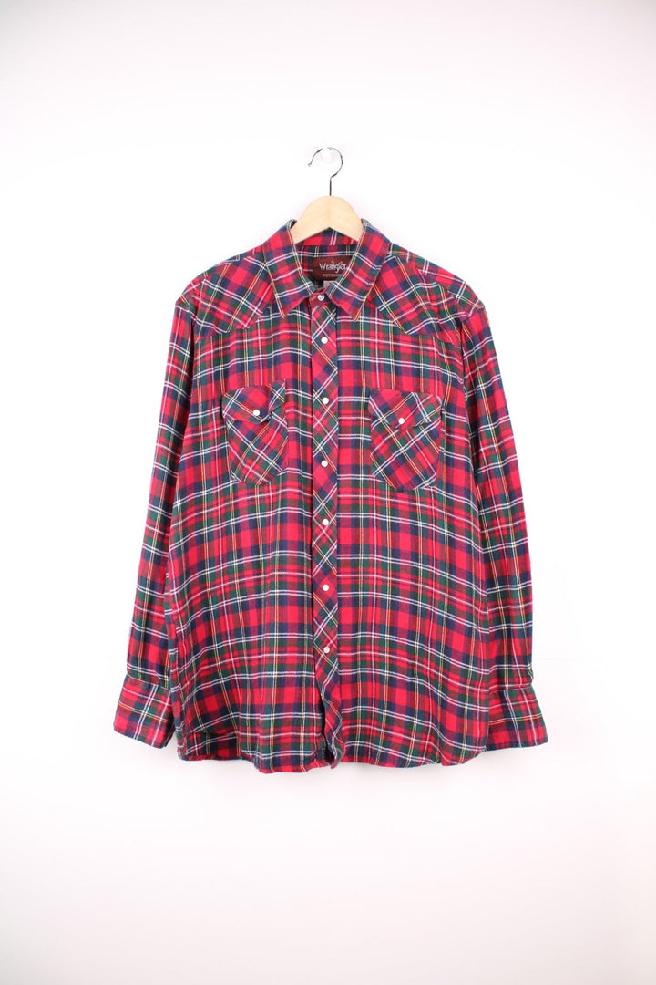 Wrangler shirt in red, green, and blue check with Western style yoke, pearl-effect snap closure and double flapped pockets.