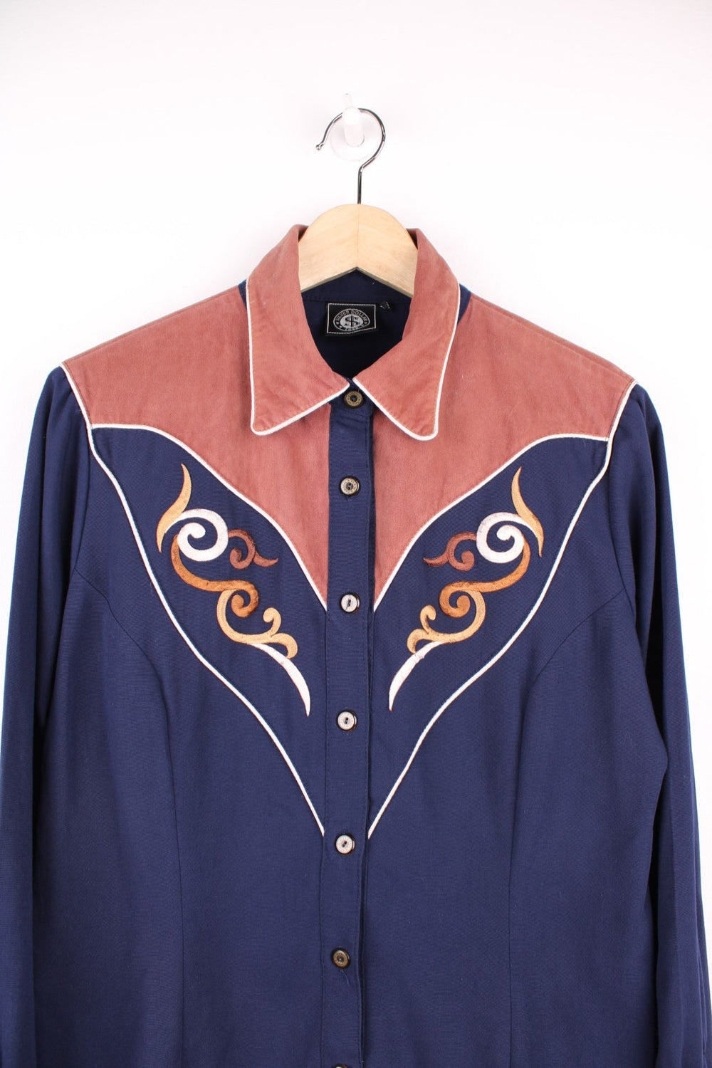 Navy blue western shirt by Silver Dollar with a brown contrast yoke and cuffs, white piping and embroidery on the front and back. 