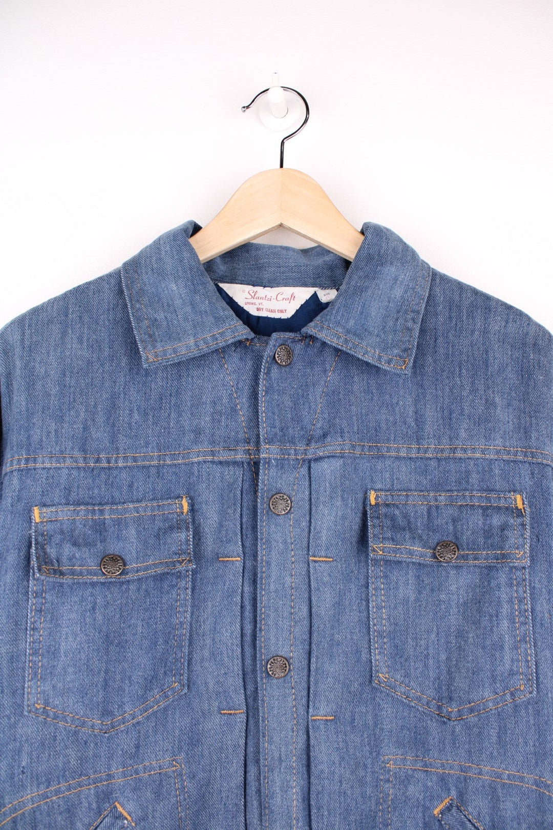 Slantzi-Craft blue denim shirt jacket with a western embroidered back yoke panel, four pockets and button closure. 