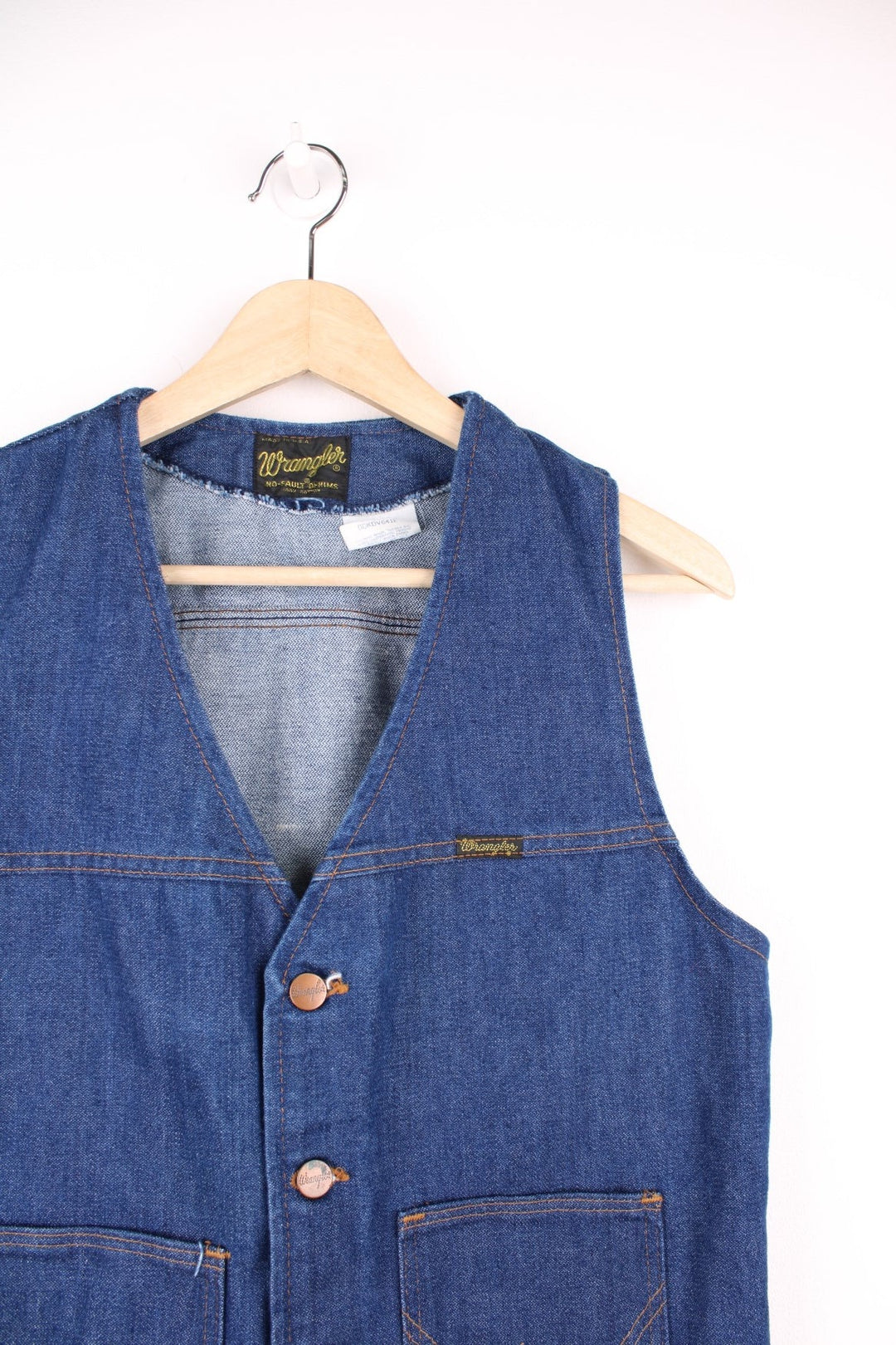 Wrangler Made in the USA 'No Fault' blue denim vest with button closure and two 'W' embroidered patch pockets. 