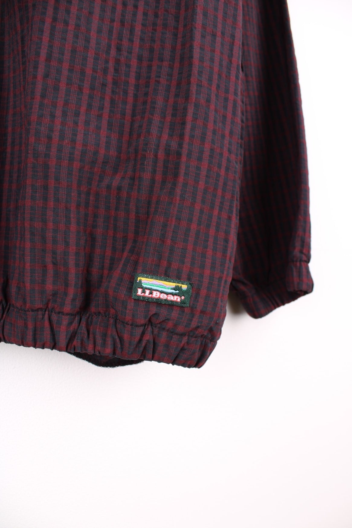 L.L. Bean Pullover Windbreaker in a red and black checkered colourway, half zip up with side pockets, chest pocket, has the logo embroidered by the hem and 3m reflective triangle on the back.