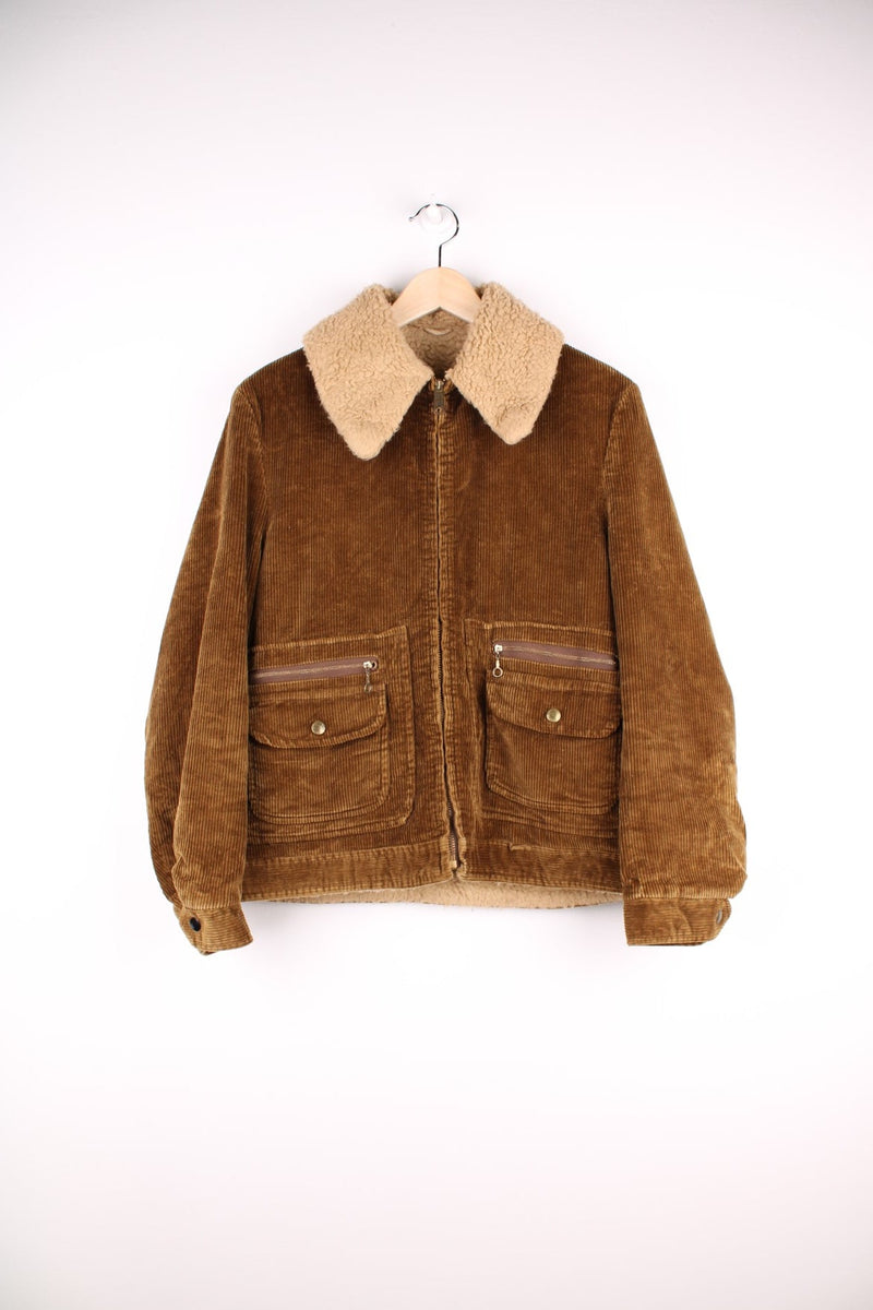 Vintage 80's Corduroy Sherpa Jacket in a brown colourway, zip up with multiple pockets, dagger collar, and has a sherpa lining.