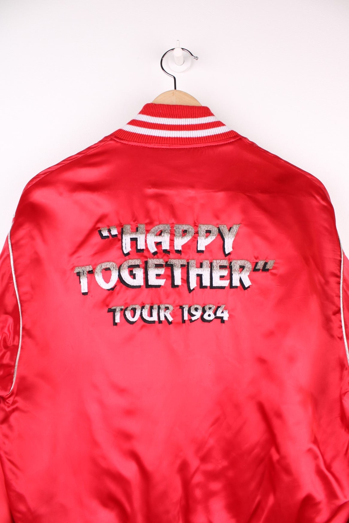 Happy Together Tour 1984 Varsity Jacket, this iconic tour featured the bands Gary Puckett, The Association, Spanky McFarlane and The Turtles. Is in a red and white colourway, buttons up with side pockets and has the spell out logo embroidered on the back.