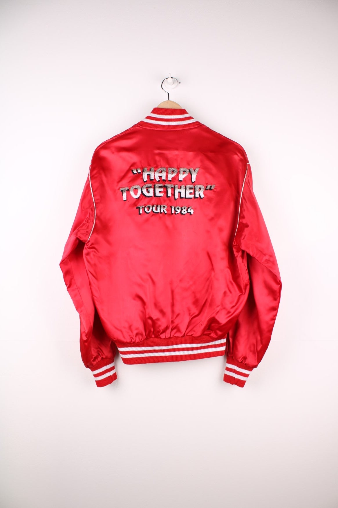 Happy Together Tour 1984 Varsity Jacket, this iconic tour featured the bands Gary Puckett, The Association, Spanky McFarlane and The Turtles. Is in a red and white colourway, buttons up with side pockets and has the spell out logo embroidered on the back.