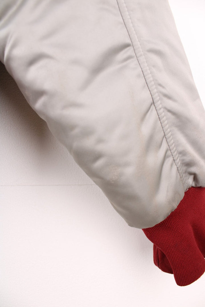 The Line' Denver, Colorado bomber-style goose down ski jacket in silvery grey with red piping, hem and cuffs, a faux fur collar, zip closure and two pockets.