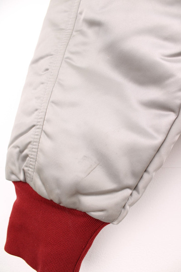 The Line' Denver, Colorado bomber-style goose down ski jacket in silvery grey with red piping, hem and cuffs, a faux fur collar, zip closure and two pockets.