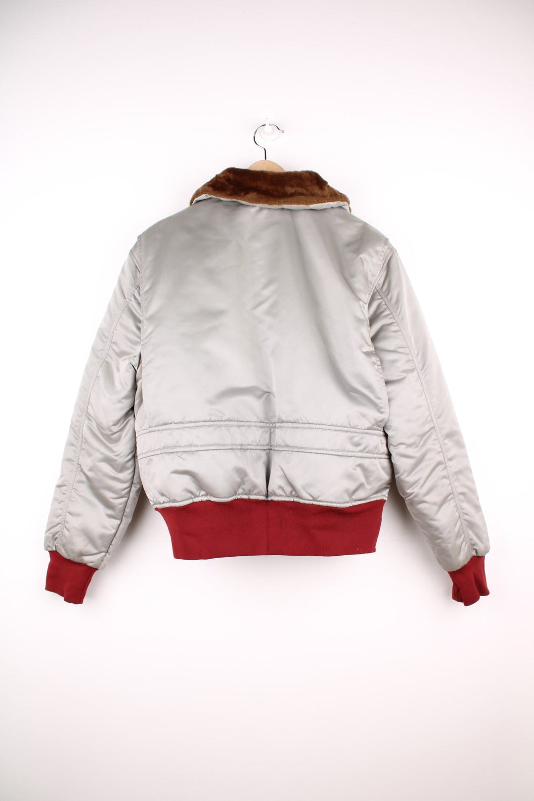 The Line' Denver, Colorado bomber-style goose down ski jacket in silvery grey with red piping, hem and cuffs, a faux fur collar, zip closure and two pockets.