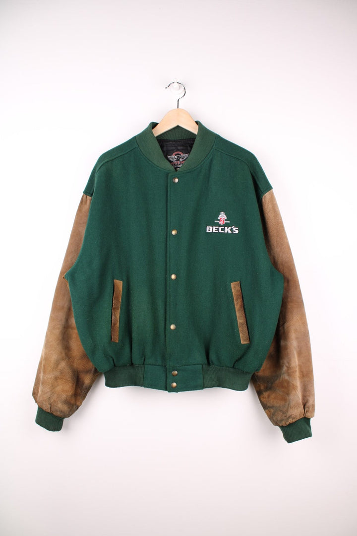 Becks Beer Varsity Jacket in a green and brown colourway, button up and has side pockets, insulated with a quilted lining, and has the logo embroidered on the front.