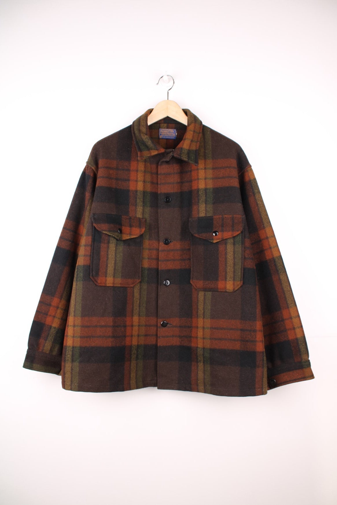 Pendleton brown plaid CPO jacket with two flap pockets and button closure. 