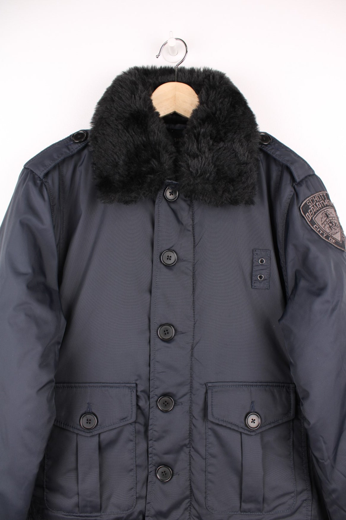 Schott NYC black pilot jacket with a removable faux fur collar, quilt lining, zip and button closure, two buttoned pockets, and epaulette loops on the shoulders. 