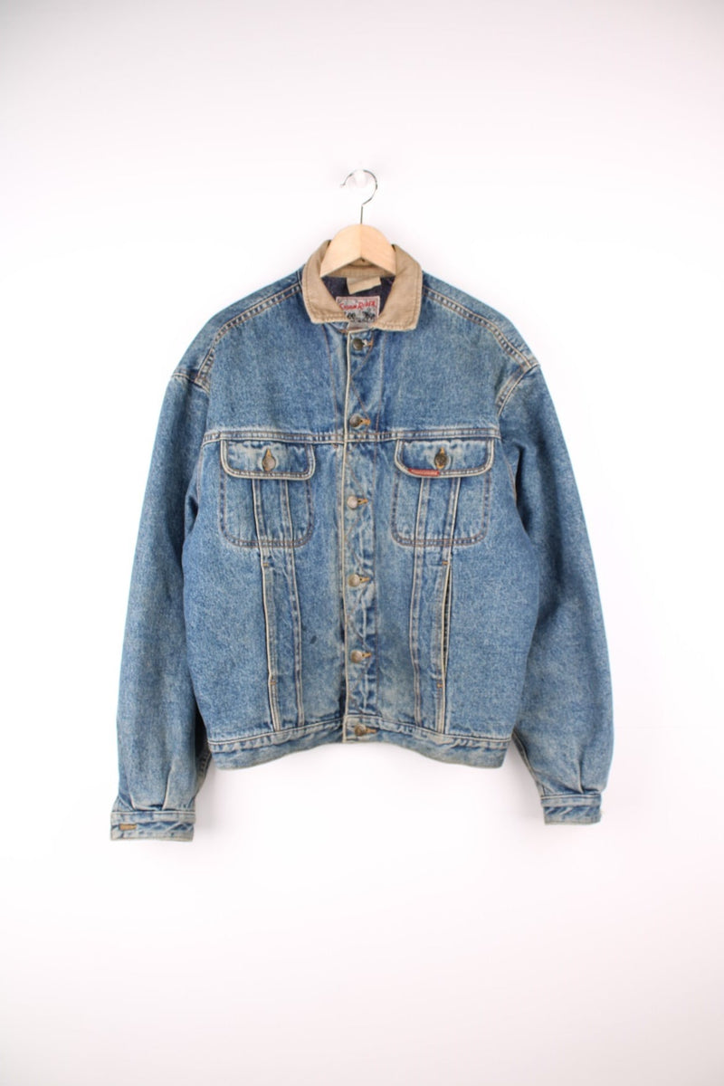 80s Lee Storm Rider denim jacket with blanket lining, four front pockets, 'Lee' branded button closure, and a red 'Rough Riders' patch on the left breast pocket. 