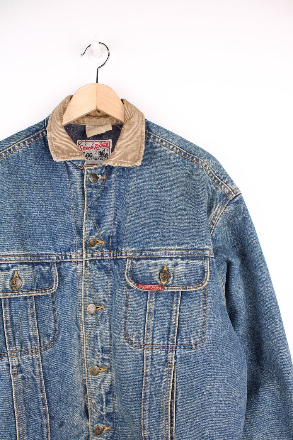 80s Lee Storm Rider denim jacket with blanket lining, four front pockets, 'Lee' branded button closure, and a red 'Rough Riders' patch on the left breast pocket. 