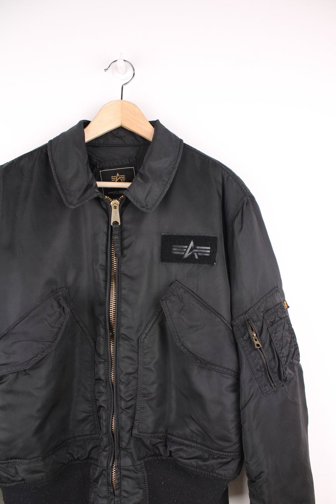 Alpha Industries black bomber jacket with zip closure, two front flap pockets and an arm pocket.