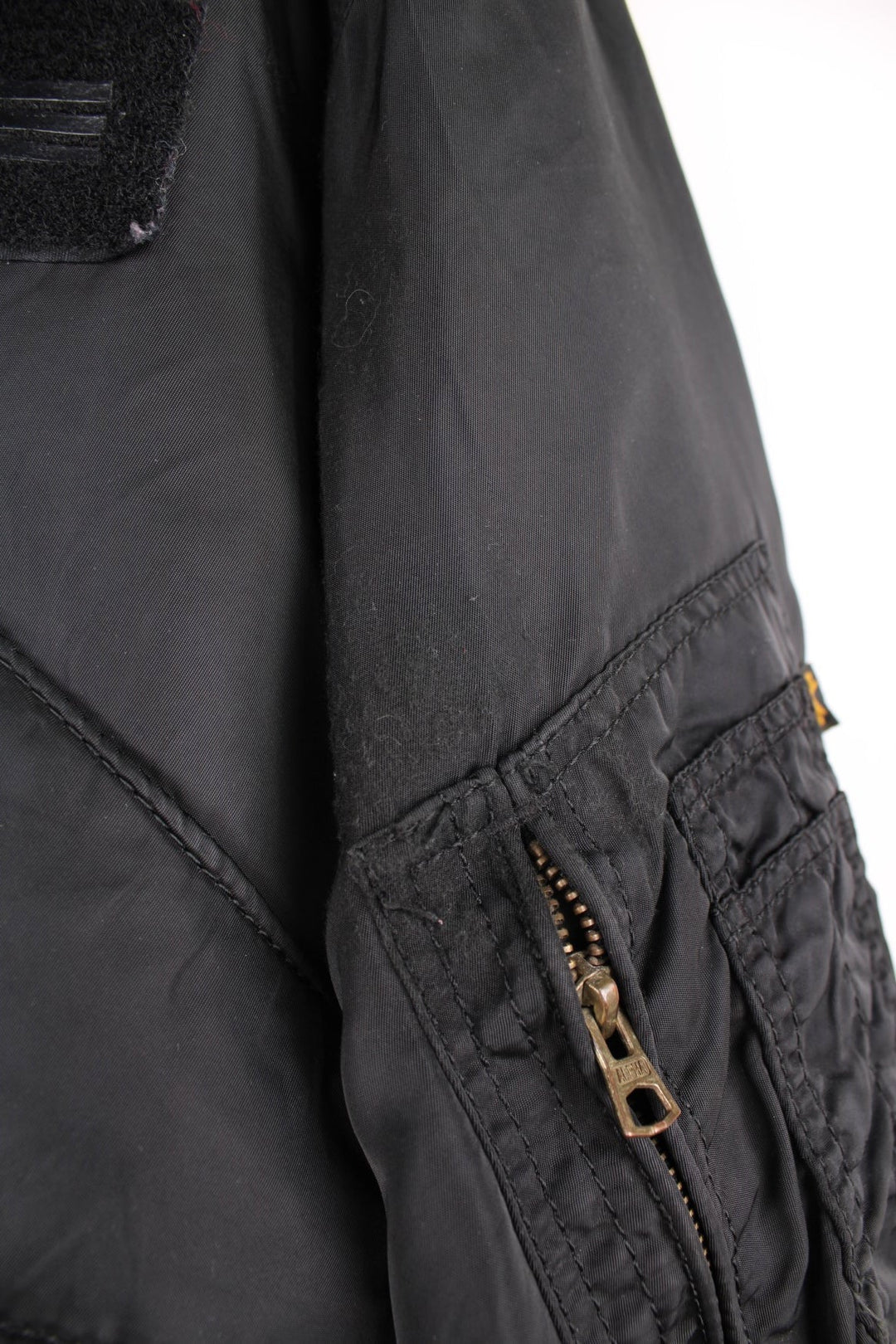 Alpha Industries black bomber jacket with zip closure, two front flap pockets and an arm pocket.