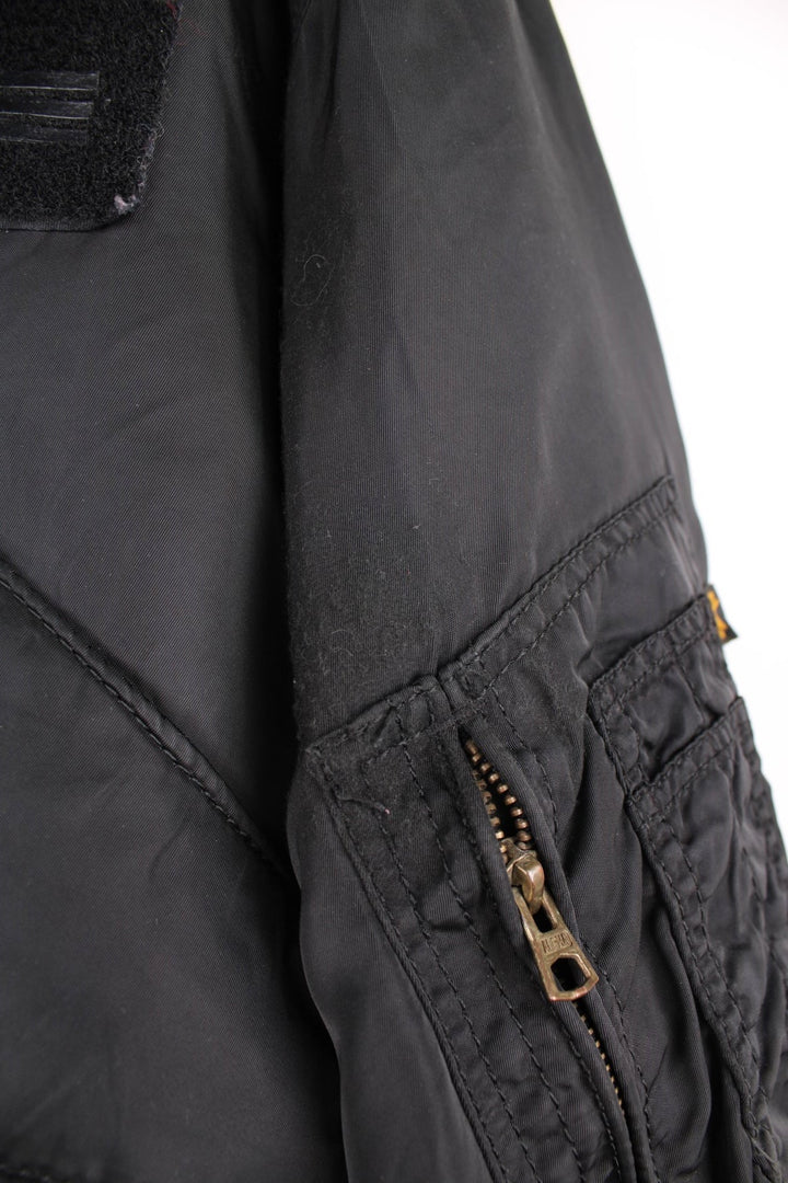 Alpha Industries black bomber jacket with zip closure, two front flap pockets and an arm pocket.