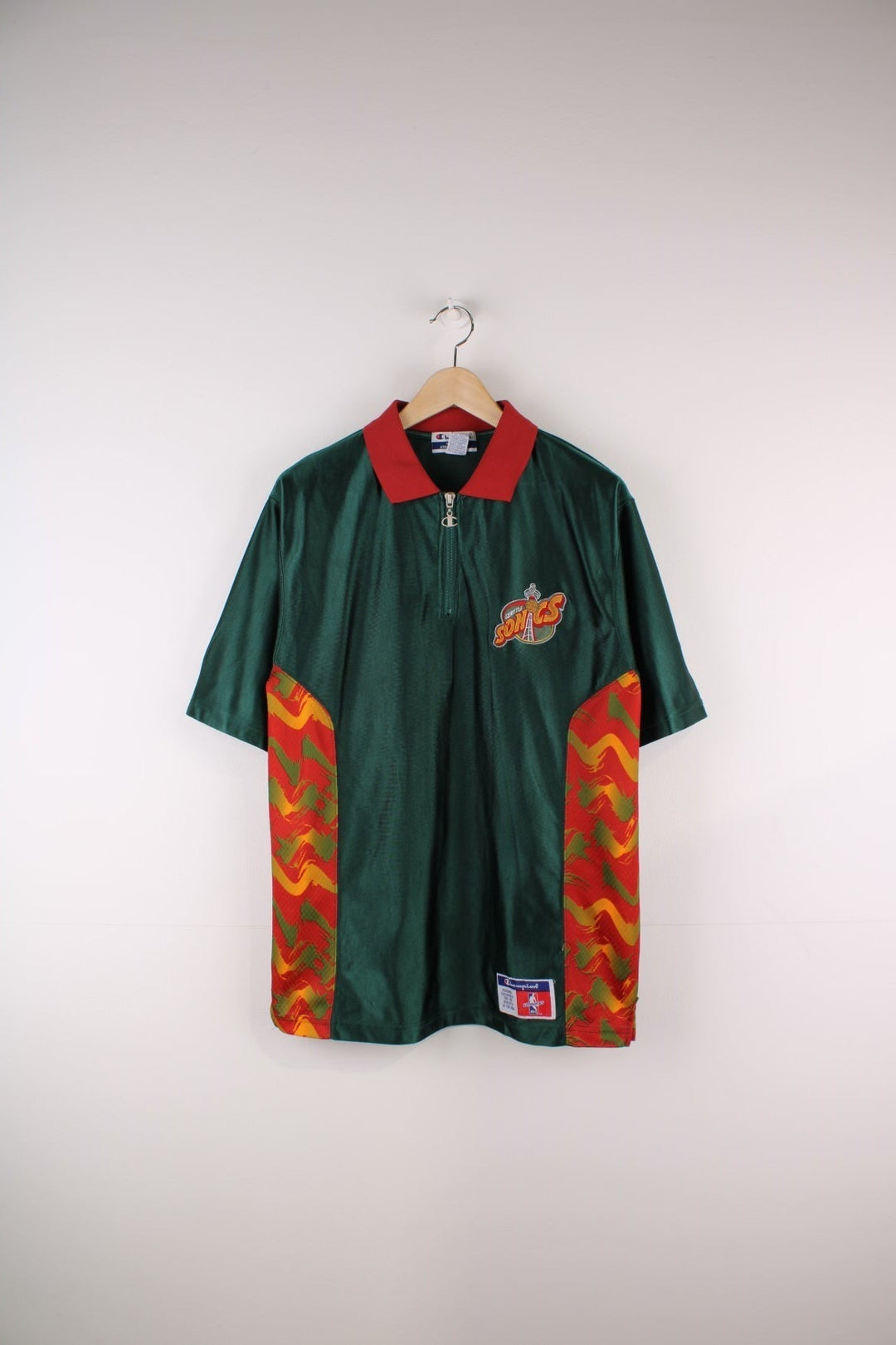 Seattle Supersonics NBA Polo Warm Up Champion Jersey in a green and red colourway with patterned stripes going down the sides, features quarter zip and has the team logo embroidered on the front and the spell out on the back.