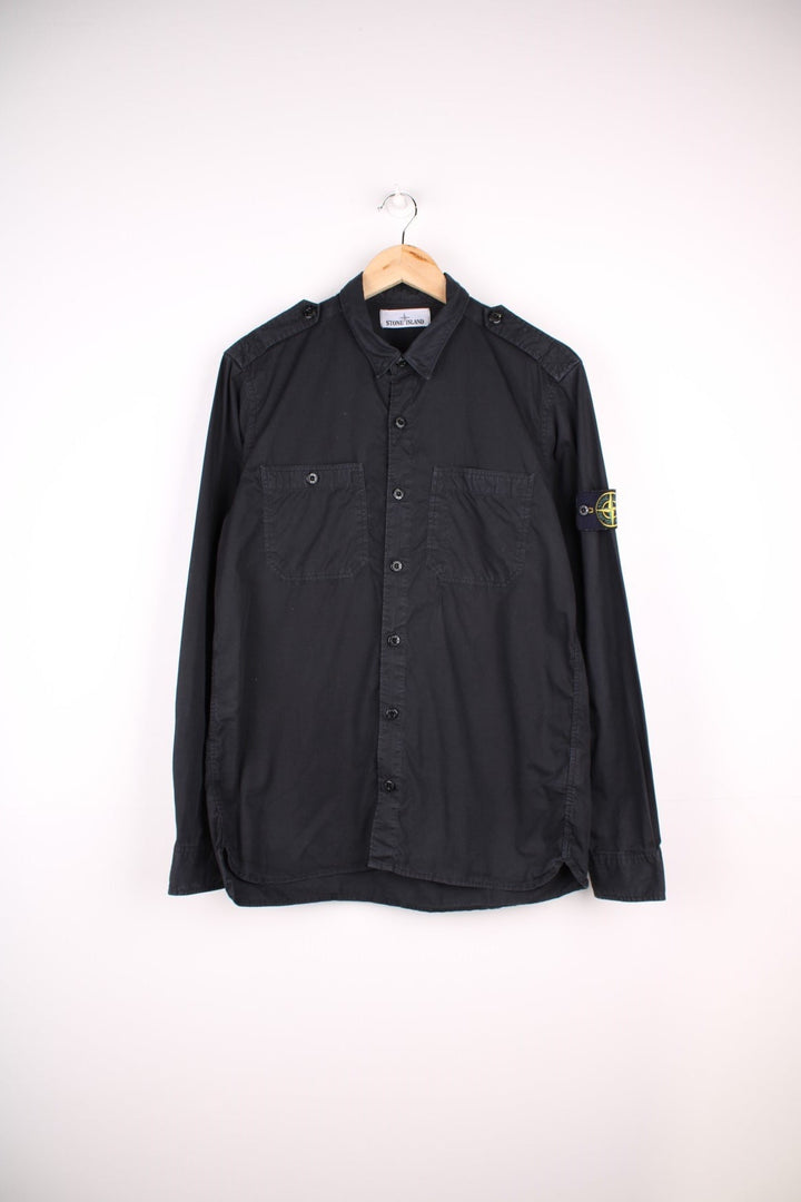 Stone Island Shirt in a black colourway, button up with double chest pockets, and has the badge logo on the left sleeve.