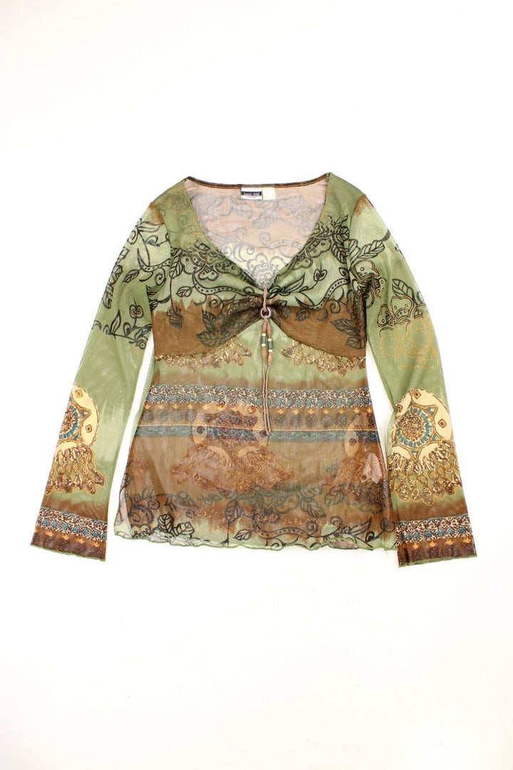 Y2K sheer boho top in green with floral patterns, lettuce hem and cuffs, a ruched bust, and a beaded decorative cord on the front.