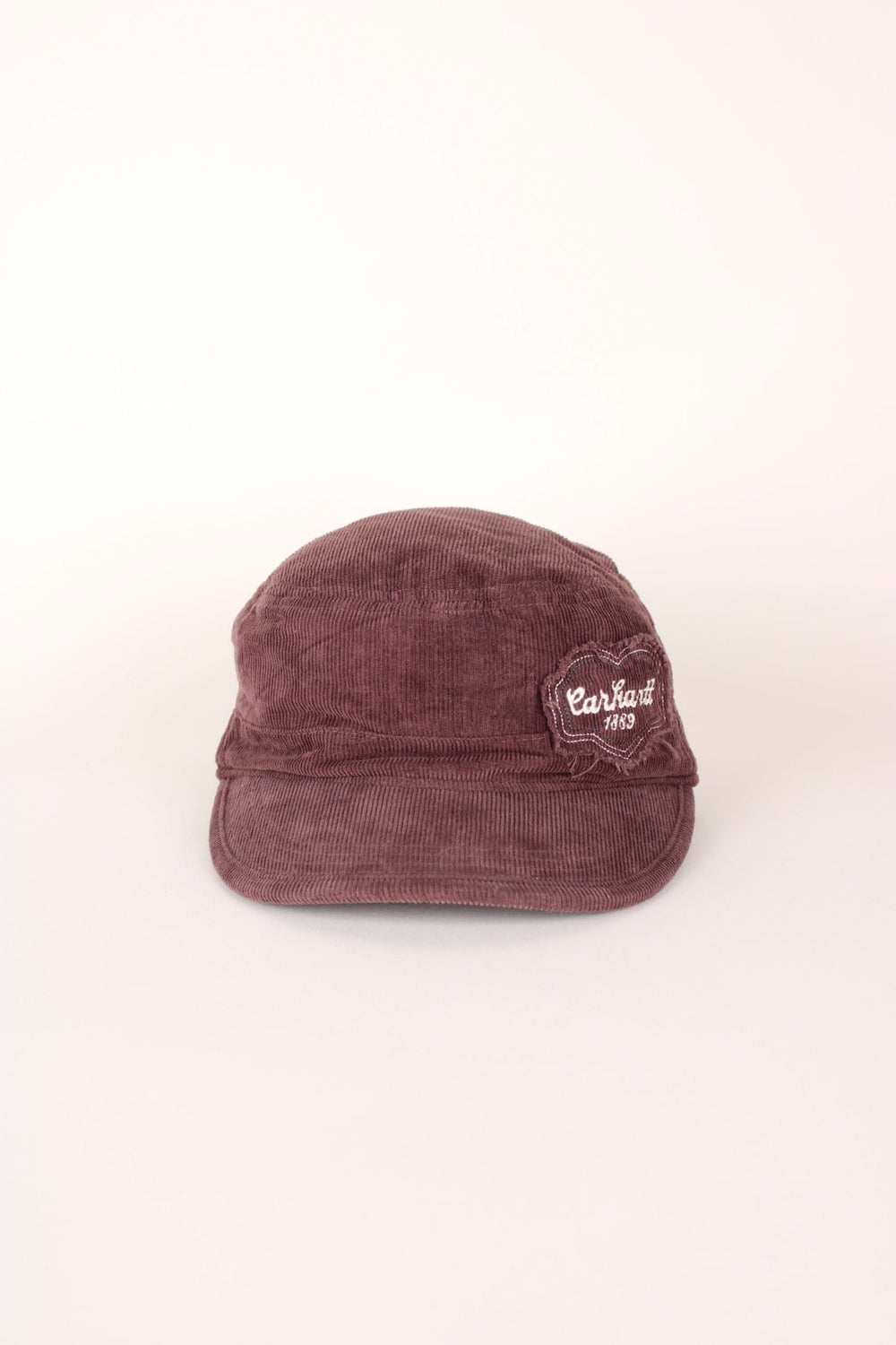 Carhartt 1889 Corduroy Cap in a burgundy courway with logo embroidered on the front and back, and has a adjustable velcro strap.