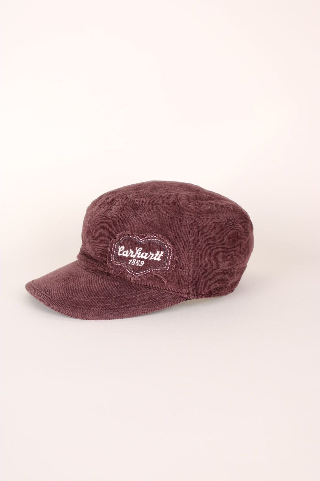 Carhartt 1889 Corduroy Cap in a burgundy courway with logo embroidered on the front and back, and has a adjustable velcro strap.