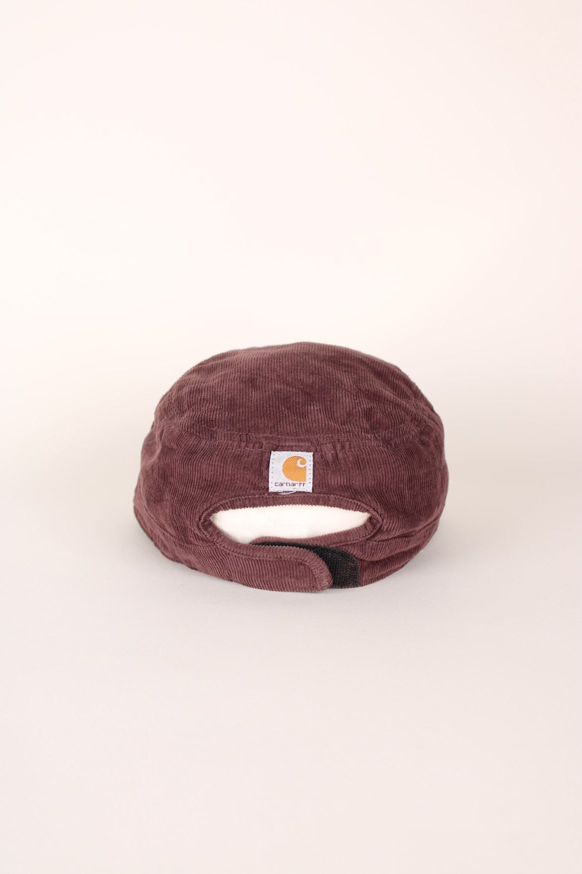 Carhartt 1889 Corduroy Cap in a burgundy courway with logo embroidered on the front and back, and has a adjustable velcro strap.