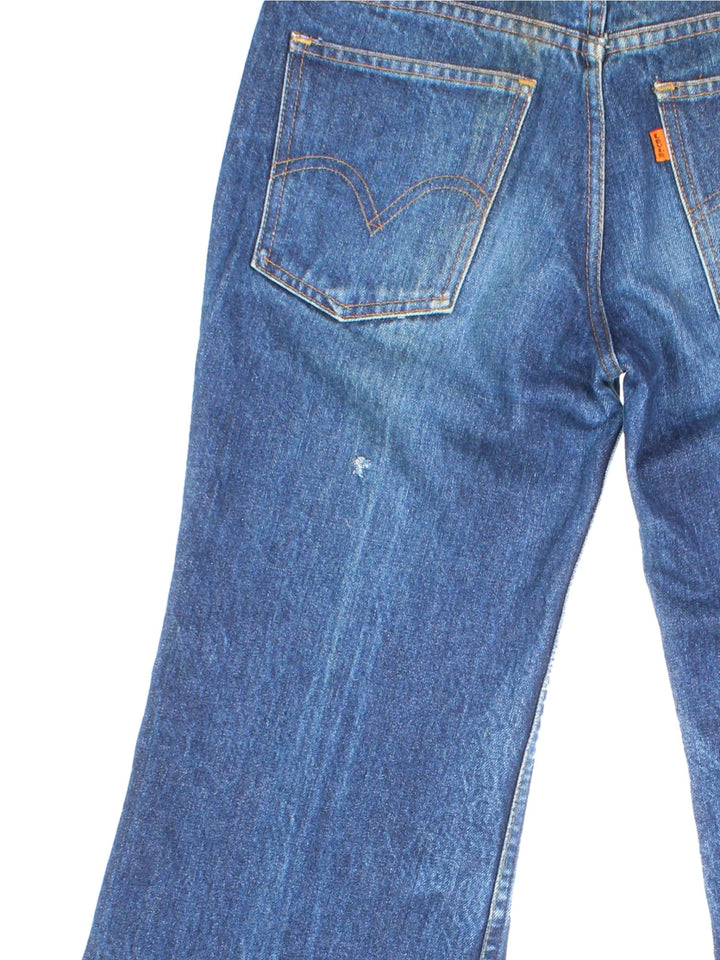 Levi Strauss flared jeans in blue with four pockets, zip and button closure, and a logo patch on the back.