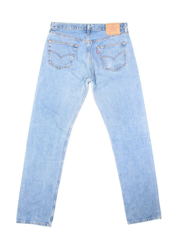 Levi Strauss jeans in a light blue wash with four pockets, zip and button closure, and a logo patch on the back.