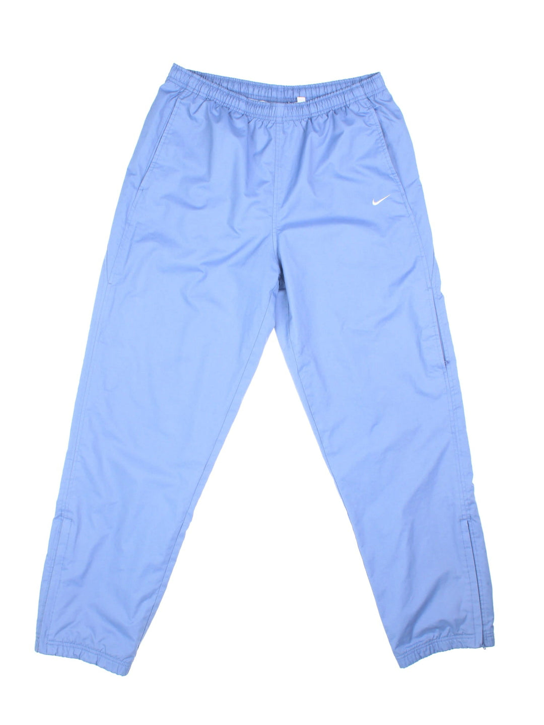 Nike tracksuit bottoms in sky blue with two pockets, an elasticated waistband, and a small embroidered swoosh logo on the front.