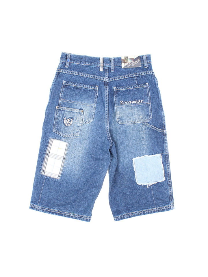 Y2K Rocawear patchwork denim shorts in blue  with four pockets, zip and button closure, several embroidered logos and a logo patch on the back.